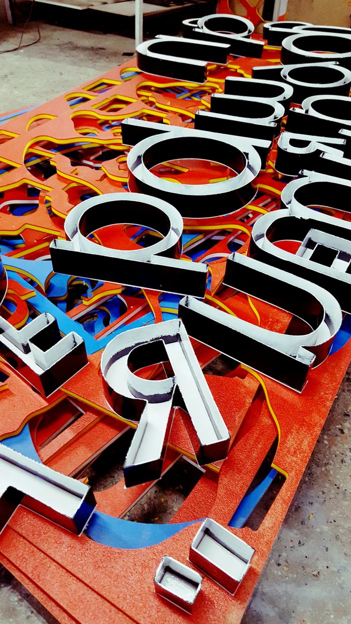 who-we-are Vibrant neon letters arranged artistically, showcasing a unique signage design.
