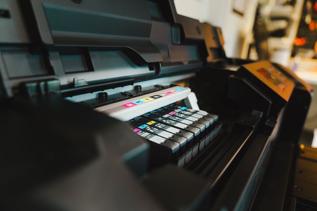 team-03 Detailed view of ink cartridges inside a digital inkjet printer in an office setting.