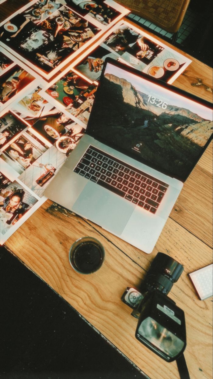 why-choose-us Flat lay of a creative workspace with a laptop, camera, and printed photographs.