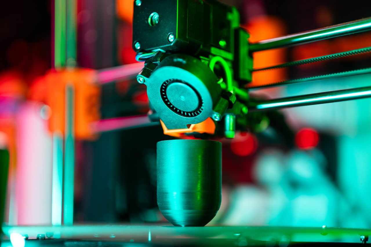 The Art of Drawing Readers In: Your attractive post title goes here Close-up of a 3D printer creating a product in neon lighting.